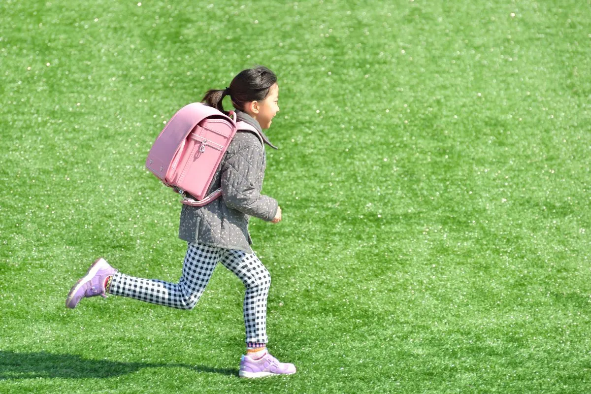 ランドセルを背負って走る女の子の画像